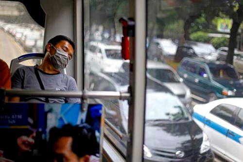 A man wearing face mask sleeps inside a TransJakarta bus amid congested traffic in Jakarta, in this file photo taken on June 12, 2013. (Reuters Photo/Beawiharta)