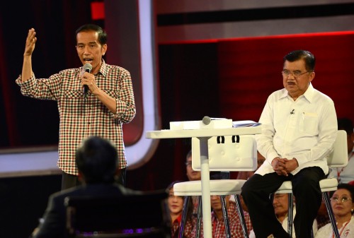 Presidential candidate Joko Widodo, left, talks as running mate Jusuf Kalla, right, listens in the fifth and presidential debate in Jakarta on Saturday. Joko wore his trademark checkered shirt for the first time in the debate series. (Antara Photo/Prasetyo Utomo)